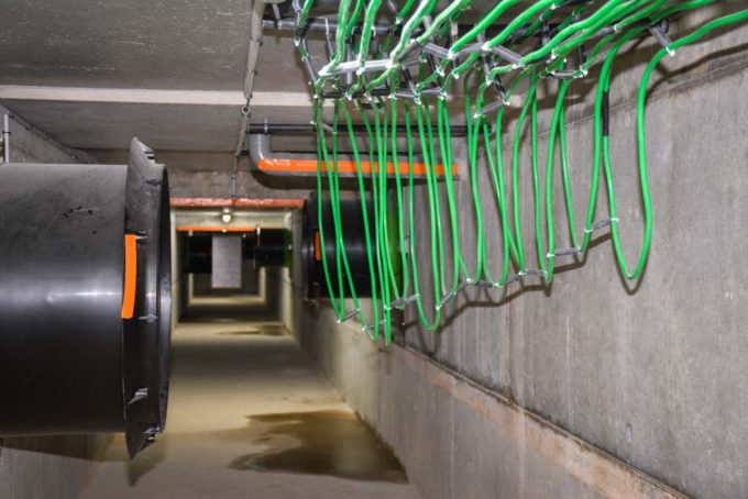 Le bâtiment est équipé d'une gaine centralisée d'extraction de l'air chaud et vicié. Les calories y sont récupérées à l'aide d'un gaz circulant dans un circuit de tuyaux de cuivre plastifié (en vert). Une pompe à chaleur récupère ces calories pour chauffer de l'eau qui circule sous les plaques chauffantes en maternité et dans une unité de soufflage dans les combles (échange eau-air). Cette unité assure un minimum de 12°C de température dans les combles (séparées au-dessus de chaque compartiment du bâtiment) toute l'année. 