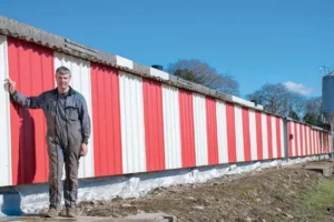 René le Du devant son bâtiment isolé il y a 1 an et demi grâce à de la mousse de polyuréthane (pignon et les soubassements latéraux).