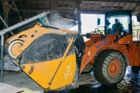 Lorsque l’ensilage est chargé dans le godet l’éleveur se positionne sous la goulotte pour incorporer le mélange d’aliments secs.