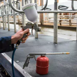 Pour lutter contre la dermatite, un tuyau dérivé du système à air comprimé du plancher mobile alimente un pistolet à peinture. « On nettoie les pieds en début de traite pour laisser le temps de sécher puis on traite. Un premier pistolet pour pulvériser un désinfectant une fois par mois, un autre pour appliquer un produit à l’Aloe vera pour traiter un animal en particulier. Les premiers tests sont concluants. »