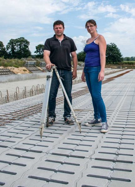 Cathy et Yvan Peucet devraient inaugurer leur nouveau bâtiment cet hiver. Impatients de traire dans une salle de traite mieux dimensionnée à leur cheptel, ils prennent la pose sur la future aire d’exercice sur caillebotis. 