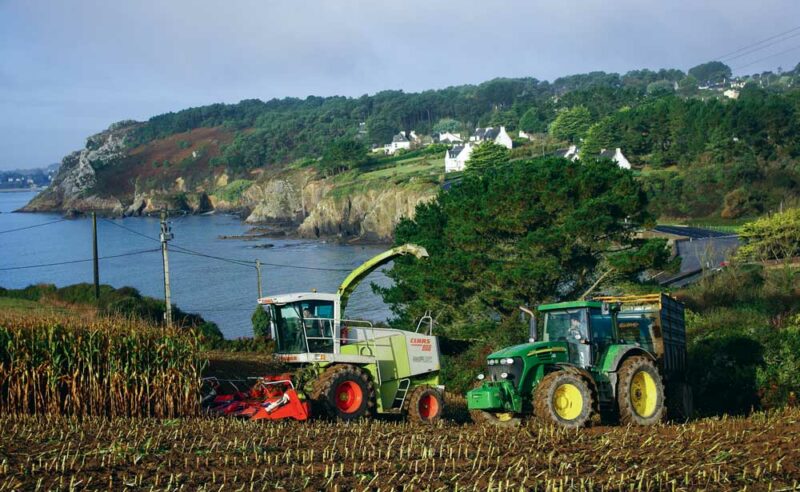 Le photographe apprécie de placer les machines au travail, son sujet principal, dans le paysage côtier breton.