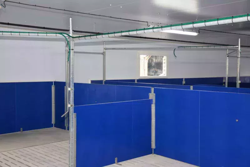 À l'intérieur, le plafond et les murs sont en panneaux isolés (mousse isolante rigide). Ils sont assemblés selon le principe « tenon-mortaise », ce qui évite les ponts thermiques. La couche intérieure du panneau est en PVC ce qui facilite le lavage et sécurise le sanitaire. La distribution d'aliment est automatisée (système Gestal).
