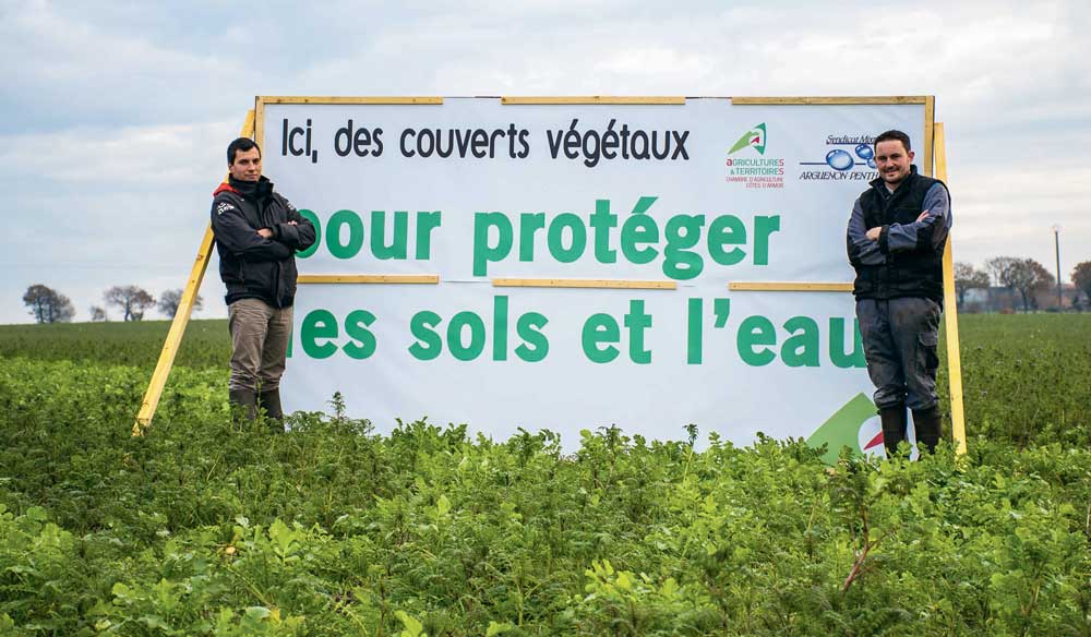 David Bouvier de la Chambre d’agriculture de Dinan et Jérémy Réhel , responsable cultures à la SCEA de la Navette, présentent le panneau de communication placé dans la parcelle d’essais de couverts au bord de la RN 12 à Plénée-Jugon. - Illustration Parlons couverts végétaux