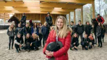 Dans le nouveau manège du lycée de Kernilien, Julie Massey prend la pose avec sa classe de Bac Pro CGEH accompagnée de Stéphane Quéméner, enseignant en techniques équestres.