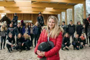 Dans le nouveau manège du lycée de Kernilien, Julie Massey prend la pose avec sa classe de Bac Pro CGEH accompagnée de Stéphane Quéméner, enseignant en techniques équestres.