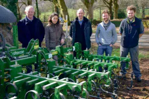 De gauche à droite : Michel Uzenot, Pauline Bellay, Lycée du Gros Chêne, Pierre Le Corre, Étienne Richard, adhérents de la Cuma et Maxime Jego, chauffeur, devant la bineuse Garford à guidage Robocrop.