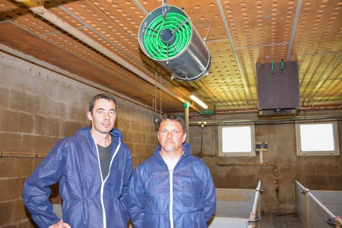 Bruno Hélo (à gauche) et Stéphane Richard, installateur, sous l'un des brasseurs. Chaque salle en possède deux, reliés chacun à l'un des capteurs placé dans les cheminées (au second plan). Un simple lavage à l'eau entre deux bandes suffit pour les nettoyer. Les capteurs, dans les cheminées s'autonettoient en mode chauffage (condensation).