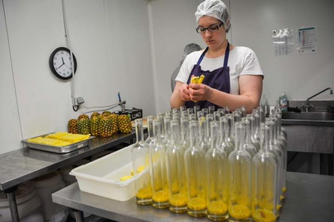 Les fruits frais sont découpés, puis insérés dans les flacons.