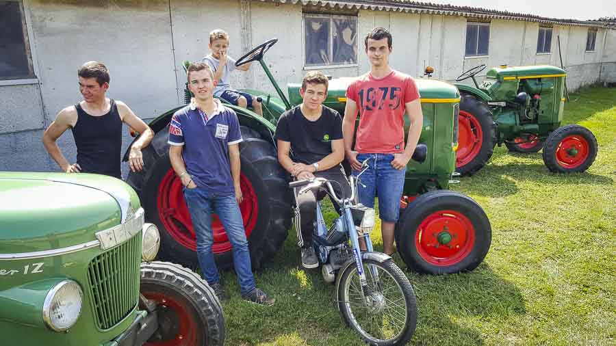 De gauche à droite, Louis Rosalie, Kevin Robert, Gabin Kerveno, Anthony Harmonet et Antoine Bartholomes (absent sur la photo) partagent leur passion à un jeune voisin. - Illustration Tracteur : Un voyage dans le temps d’un siècle en une journée