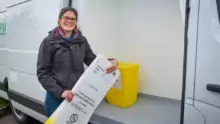 Charline Leroy, responsable commerciale, devant l'un des camions dédié au service nommé Pure Logistique. Un box isolé permet le stockage des cartons propres. Le reste du véhicule est réservé aux cartons pleins.