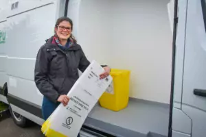 Charline Leroy, responsable commerciale, devant l'un des camions dédié au service nommé Pure Logistique. Un box isolé permet le stockage des cartons propres. Le reste du véhicule est réservé aux cartons pleins.