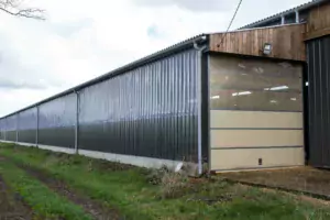 Dans la stabulation, deux couloirs de service de part et d’autre de l’aire paillée.