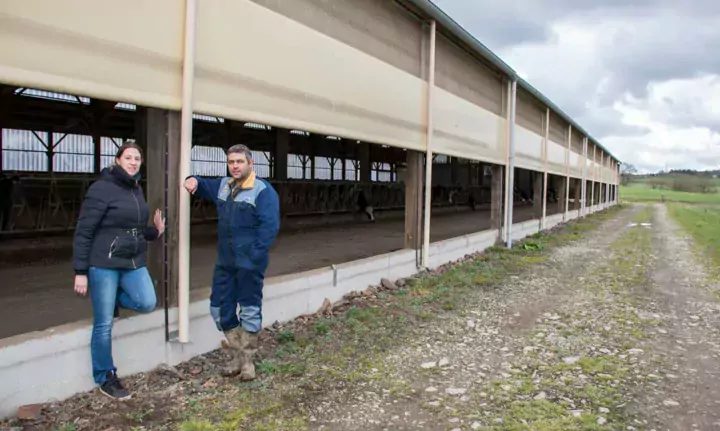 Myriana Hillion et Adrien Gléhello devant la nouvelle stabulation. « Dès qu’il y a une belle journée, j’ouvre en matinée », explique l’éleveur.