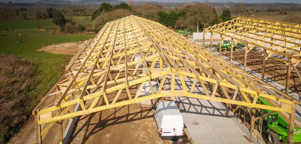 Vue d’ensemble d’une charpente en double chapelle en treillis en construction à Loguivy-Plougras. - Illustration La précision au service de la robustesse