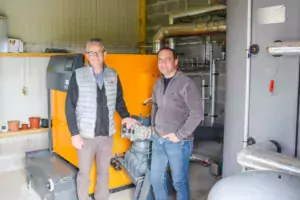 Stéphane Dahirel, aviculteur à Lanouée (56), et Raphaël Lemercier, responsable technique chez GRD thermique, devant la chaudière à biomasse de 130 kW de puissance.
