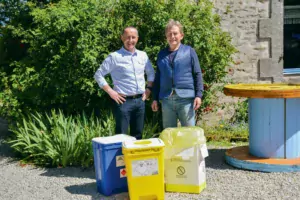 Guy Le Bouter et Bruno Robert, responsable de secteur La Collecte Médicale, présentent les containers de couleur qui correspondent chacun à un type de déchets d'élevage.