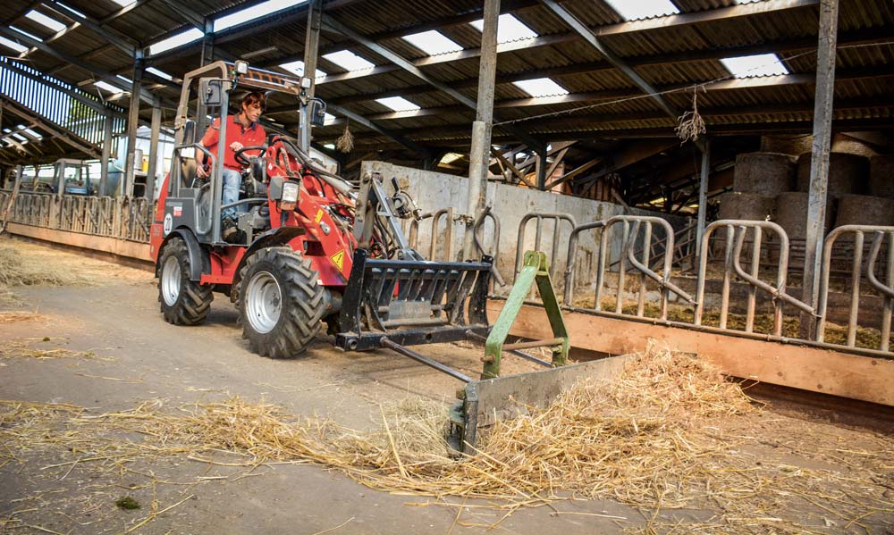 Le valet de ferme est aussi très utile pour pousser le fourrage ou faire un peu de nettoyage dans la stabulation. - Illustration Le valet de ferme travaille en silence