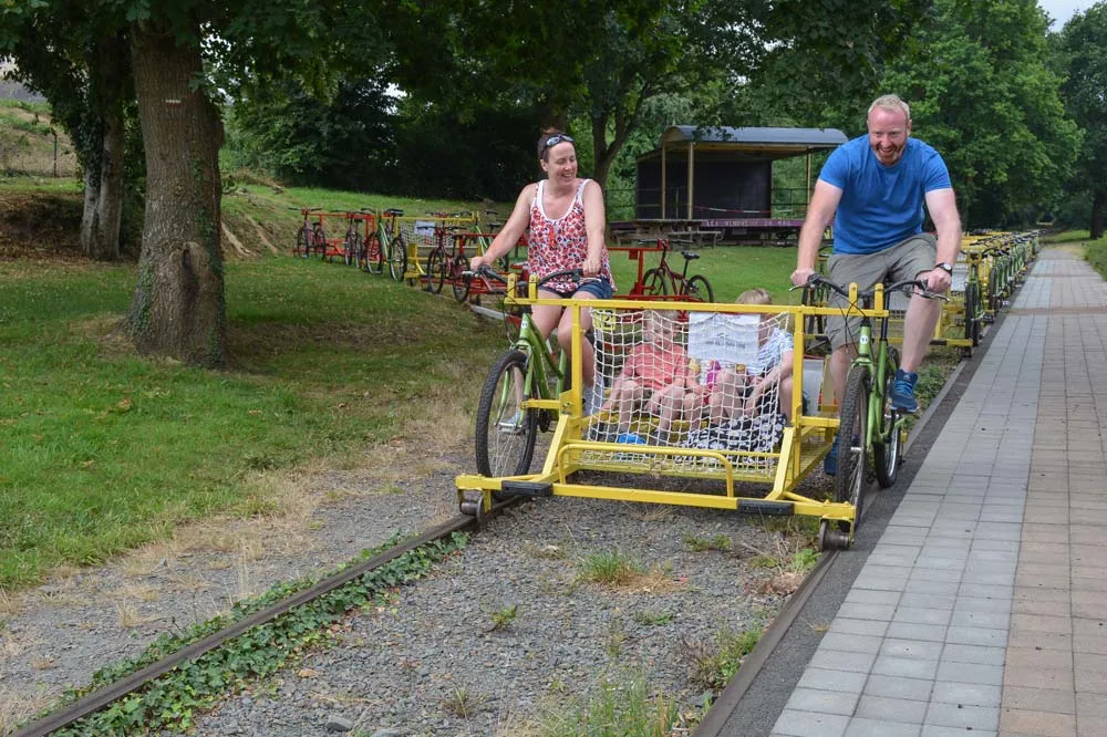C’est parti pour ce couple de touristes anglais venus faire un peu de sport tout en découvrant les alentours de Médréac. - Illustration Balade en vélo sur les rails