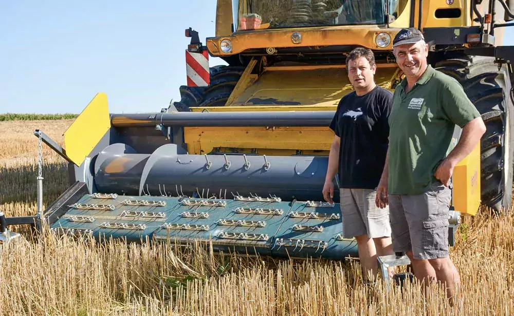 Jean-Yves Louedec, à droite, et Erwan Le Merrer, de l'ETA de Saint- Nicodème qui réalise la moisson, devant la moissonneuse équipée du bec pick-up à courroie. - Illustration Il fauche son blé pour gagner en maturité