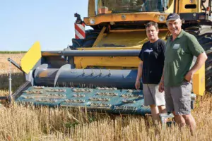 Jean-Yves Louedec, à droite, et Erwan Le Merrer, de l'ETA de Saint- Nicodème qui réalise la moisson, devant la moissonneuse équipée du bec pick-up à courroie.