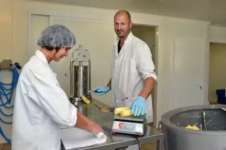 Benoît à la découpe, Isabelle à l’emballage. Le beurre au lait cru se conserve certes moins longtemps mais il garde toutes les qualités organoleptiques d’un lait de ces vaches exclusivement nourries à l’herbe et au foin séché.