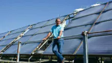 Christian Merret, éleveur de veaux de boucherie à Henvic (29) devant ses panneaux solaires thermiques.