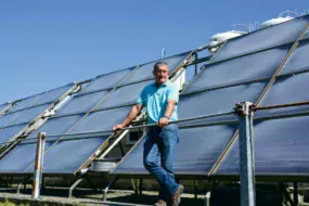 Christian Merret, éleveur de veaux de boucherie à Henvic (29) devant ses panneaux solaires thermiques.