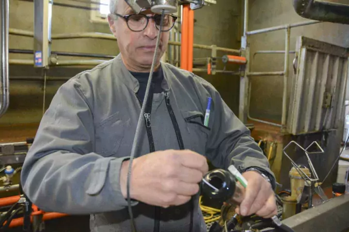 Yvon Henry procède à la prise d’échantillon dans un manchon, à l’aide d’un écouvillon.