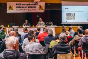 À la tribune du meeting de la Confédération paysanne à la Maison de l’agriculture de Plérin, Emmanuelle Billard et Manu Louail, candidats dans les Côtes d’Armor, entourant Nicolas Girod du syndicat national.