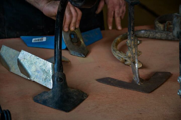 Différents socs de bineuses (et dents de herses) étaient présentés dans l'atelier. À gauche, une ailette a été installée derrière un soc pour butter légèrement le rang lors du binage. 