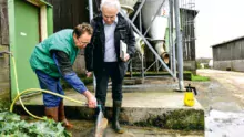 Patrick Robert, éleveur laitier à Bréhand-Moncontour montre à Félix Mahé comment, en les déchaussant à moitié, il est facile de nettoyer le dessous des bottes avant d’entrer dans la stabulation. Qui dit « bio sécurité » n’exclut pas bon sens paysan et pragmatisme !