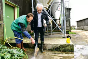 Patrick Robert, éleveur laitier à Bréhand-Moncontour montre à Félix Mahé comment, en les déchaussant à moitié, il est facile de nettoyer le dessous des bottes avant d’entrer dans la stabulation. Qui dit « bio sécurité » n’exclut pas bon sens paysan et pragmatisme !