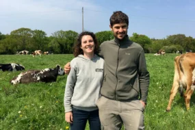 Des éleveurs laitiers dans une prairie au milieu de leurs vaches