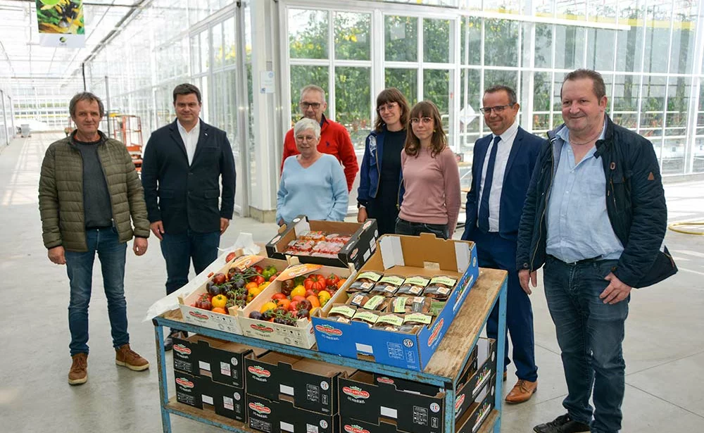 Un groupe de personnes devant un étal de légumes plus résistants à la sécheresse. - Illustration Observer les végétaux plus résilients