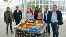 Un groupe de personnes devant un étal de légumes plus résistants à la sécheresse.