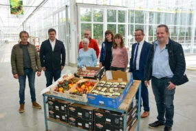 Un groupe de personnes devant un étal de légumes plus résistants à la sécheresse.