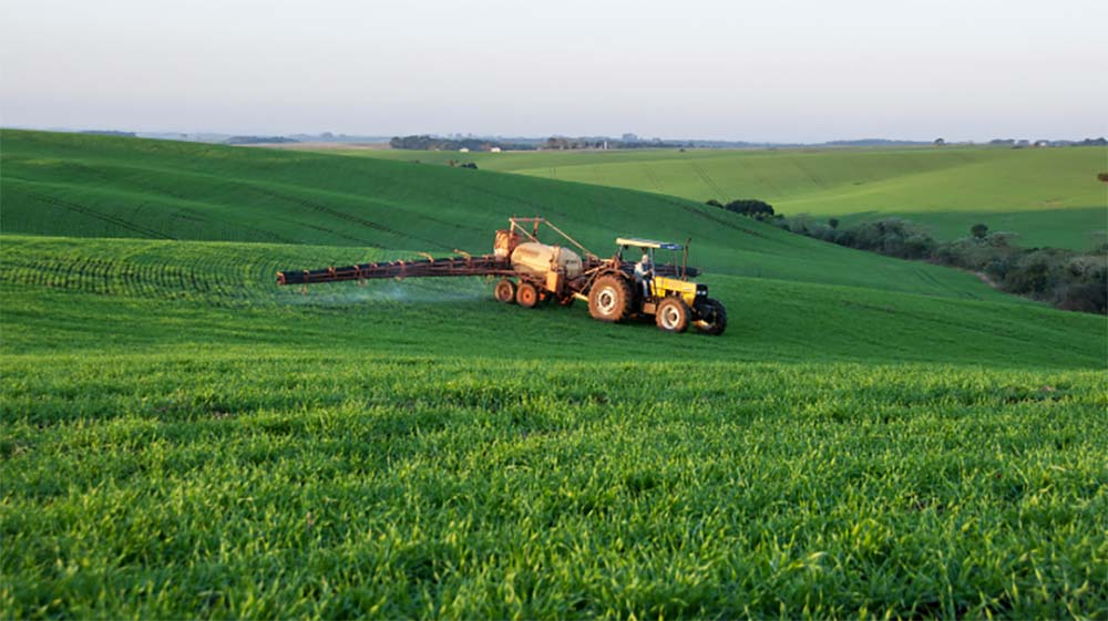 Un pulvérisateur traite un champ de blé. - Illustration Mettre à jour le registre phytosanitaire et le cahier d’enregistrement des pratiques
