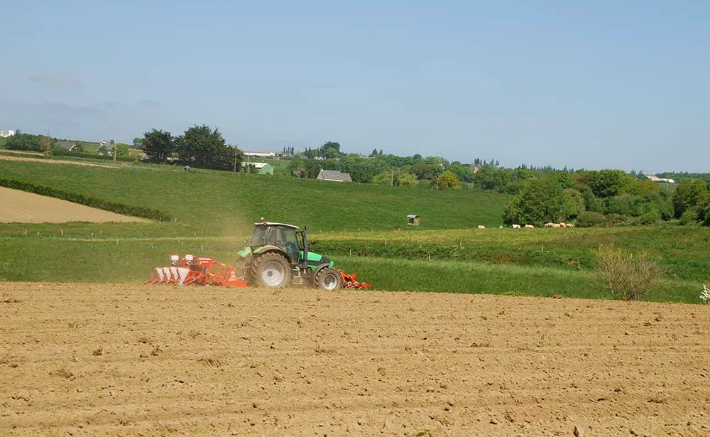 Un tracteur Deutz qui sème du maïs dans un sol bien préparé - Illustration Maïs : Bien travailler le sol pour des semis en conditions sèches