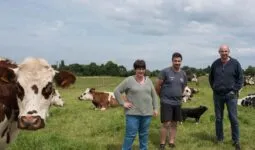 Les éleveurs Sylvie, Pierre et Xavier Le Moal dans une parcelle d'herbe avec leurs vaches Normandes.