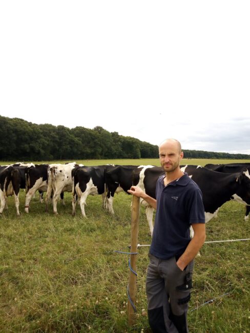 L'éleveur dans une des parcelles de pâturage avec les vaches