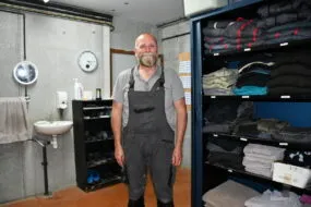 Le responsable d'élevage dans le sas bien rangé avec les vêtements et chaussures propres