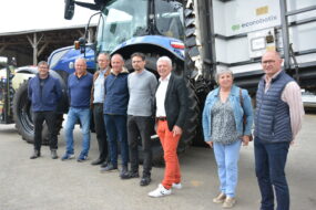 Un groupe de personnes devant un tracteur