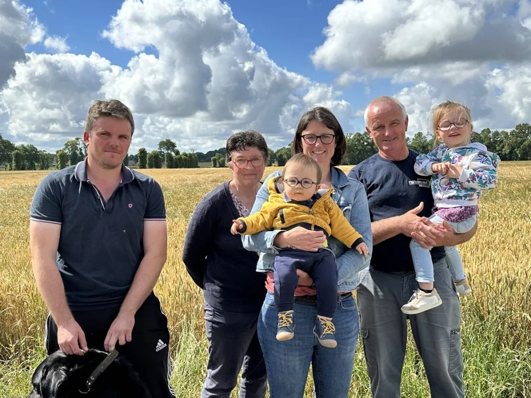 Famille d'éleveur devant champ de blé