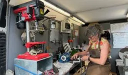 Dans sa camionnette - atelierne, une rémouleuse en train d'affûter une lame.
