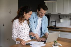 Jeune couple en train de faire ses papiers administratifs devant un ordinateur