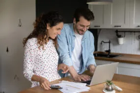 Jeune couple en train de faire ses papiers administratifs devant un ordinateur