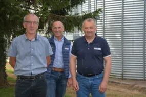 3 personnes devant une cellule de stocakge de blé