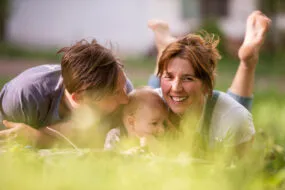 Un homme, une femme et un bébé allongés dans un chamo