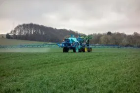 Un tracteur en train de pulvériser dans un champ